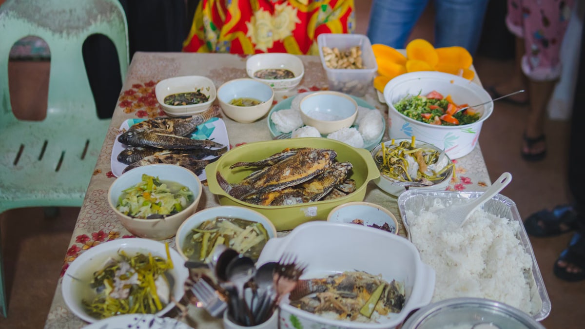 A vibrant spread of traditional Filipino dishes including fried fish and assorted side dishes on a table.